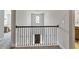 View of a hallway with iron railing looking down on a dark wooden door at 1995 Woodmont Dr, Douglasville, GA 30135