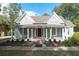 Inviting home featuring a covered front porch with columns and a red door, surrounded by manicured landscaping at 150 E Main St, Rutledge, GA 30663