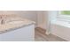 Granite countertop bathroom featuring a tub, shower, and gray wood floors at 6462 Beaver Creek Trl, Atlanta, GA 30349