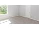 Neutral bedroom featuring carpeted floors, light gray walls, and natural light from a window at 6462 Beaver Creek Trl, Atlanta, GA 30349