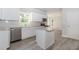 Well-lit kitchen with white cabinets, stainless steel appliances, and gray wood flooring at 6462 Beaver Creek Trl, Atlanta, GA 30349