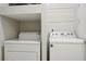 A compact laundry room area featuring a stacked washer and dryer with wire shelving above at 2700 Pine Tree Ne Rd # 1007, Atlanta, GA 30324