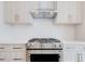 Close-up of a stainless steel gas range and oven with light wood cabinets at 1239 Chelsea Nw Cir, Atlanta, GA 30318