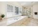 Bright bathroom featuring a tub, shutters and walk in shower at 3127 Lenox Road # 6, Atlanta, GA 30324