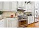 A chef-style kitchen with a stainless steel stove, white cabinets, and hardwood floors at 3127 Lenox Road # 6, Atlanta, GA 30324