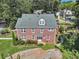 Brick home with many windows, gravel driveway, and luscious lawn at 133 Hillside Se Ave, Atlanta, GA 30315