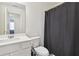 Bathroom featuring white sink, toilet, mirror, and gray shower curtain at 2688 Toucan Way, Atlanta, GA 30331