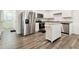 Modern kitchen with stainless steel appliances, island, granite countertop, and white cabinets and hardwood floors at 2688 Toucan Way, Atlanta, GA 30331