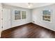 Bedroom featuring wood flooring, white walls, ceiling fan and two windows letting in natural light at 9206 Carlton Nw Trl, Covington, GA 30014