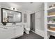 This bright bathroom features a sleek white vanity, shower with tile surround and built-in shelves for storage at 2228 Old Dallas Sw Rd, Marietta, GA 30064