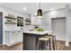 Bright kitchen features white cabinets, center island with stools, and decorative floating shelves at 2228 Old Dallas Sw Rd, Marietta, GA 30064