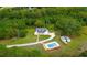 Aerial view of a single-Gathering home with a private pool and a long driveway surrounded by lush greenery at 601 Wantland Rd, Bowdon, GA 30108