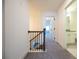 Upstairs hallway with carpet, railing, and doors to bedrooms and bathroom at 94 S Auburn Landing Pl, Auburn, GA 30011