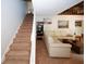 Inviting living area with plush beige carpeting, modern staircase, and a comfortable cream-colored sectional sofa at 840 Brandy Oaks Ln, Stone Mountain, GA 30088