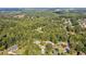 Aerial view of home, showcasing wooded lot, neighborhood, and surrounding trees at 1210 Swan Mill Ct, Suwanee, GA 30024