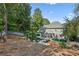 Landscaped backyard with a pool, patio, lounge furniture, and mature trees provides a relaxing outdoor space at 1210 Swan Mill Ct, Suwanee, GA 30024