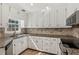 Charming kitchen featuring white cabinets, granite countertops, and stainless steel appliances at 1210 Swan Mill Ct, Suwanee, GA 30024