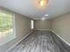 This bedroom features gray wood-look flooring, natural light from windows, and neutral walls at 32 Sherwood Loop, Mcdonough, GA 30253