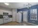 Well-lit kitchen with white appliances, granite countertops, modern pendant lighting, and backyard access at 3160 Mill Springs Cir, Buford, GA 30519