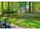 Secluded backyard featuring a shed, swing, stone path, and patio area with outdoor dining furniture at 246 Plantation Sw Rd, Smyrna, GA 30082