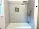 Bathroom featuring herringbone-patterned tile, shower niche, and modern shower head at 246 Plantation Sw Rd, Smyrna, GA 30082
