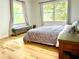 Bright bedroom with hardwood floors, large windows, and neutral bedding at 246 Plantation Sw Rd, Smyrna, GA 30082