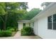 Exterior view showing the side of the home with white painted brick, green landscaping, and a well-maintained yard at 246 Plantation Sw Rd, Smyrna, GA 30082