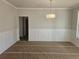 Spacious dining room with wainscoting and modern light fixture at 3292 Lions Ruby Ln, Atlanta, GA 30349