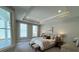 Serene bedroom boasting tray ceilings, a king bed, bench, and bright, natural light at 3587 Fishpond Cir, Dacula, GA 30019