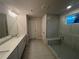 Bright bathroom features a double vanity, quartz counters, and a glass-enclosed shower with bench at 337 Willow Cv, Canton, GA 30114