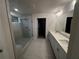 Bright bathroom features a double vanity, quartz counters, and a glass-enclosed shower with bench at 337 Willow Cv, Canton, GA 30114