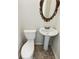 Small powder room with pedestal sink and decorative mirror at 211 Murphy Ave, Lawrenceville, GA 30044