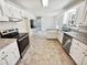 Bright kitchen featuring granite countertops, stainless appliances, white cabinets, and access to a carpeted room at 211 Murphy Ave, Lawrenceville, GA 30044