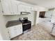 Modern kitchen with stainless steel appliances, granite countertops, and white cabinetry adjoining a cozy Gathering room at 211 Murphy Ave, Lawrenceville, GA 30044