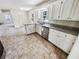 Well-lit kitchen with stainless steel appliances, granite countertops, white cabinets, and a seamless open layout at 211 Murphy Ave, Lawrenceville, GA 30044