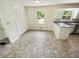 Bright kitchenette featuring white cabinetry, neutral countertop, and tiled flooring with ample natural light at 211 Murphy Ave, Lawrenceville, GA 30044