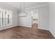 Elegant dining room featuring wood flooring, a modern chandelier, and a view into the kitchen at 482 Broom Dr, Cumming, GA 30040