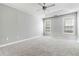 Well-lit bedroom with neutral walls, carpet flooring, and two large windows at 1055 Leighs Brook Way, Dacula, GA 30019