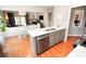 Modern kitchen with island seating, stainless steel dishwasher, and an open view to the dining and living room at 3406 Ravensworth Nw Trce, Kennesaw, GA 30144