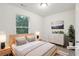 Neutral bedroom featuring a large window, wood furniture, and soft lighting creates a relaxing atmosphere at 4001 Avalon Sw Rd, Atlanta, GA 30331