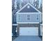 Two-story townhome with gray siding, brick accents, and a two-car garage at 133 Stanchion Dr, Union City, GA 30291