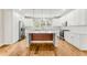 Bright kitchen with white cabinets, stainless steel appliances, wood floors, and an island with wood accents at 370 Thrasher St # 2, Norcross, GA 30071