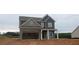 Two-story home featuring a stone facade, an attached garage, and covered front porch at 5994 Spring Way, Stonecrest, GA 30038