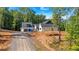 Exterior view of the home set on a lot with a long driveway and a wooded perimeter at 107 Marks Way, Canton, GA 30115
