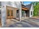 Close-up of modern farmhouse exterior featuring white board and batten, stone foundation, and wood door at 107 Marks Way, Canton, GA 30115