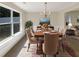 Elegant dining room featuring a chandelier, a large window, and a wooden table with seating for six at 6260 Selborn Sw Dr, Atlanta, GA 30331