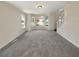 Bright open-plan living room with multiple windows, neutral carpeting, and staircase access at 6260 Selborn Sw Dr, Atlanta, GA 30331