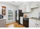 Modern kitchen with granite counters, white cabinets, and hardwood floors at 27303 Plantation Ne Dr, Atlanta, GA 30324