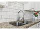 Stainless steel sink with granite countertop and subway tile backsplash at 27303 Plantation Ne Dr, Atlanta, GA 30324