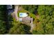 An overhead view of a secluded home with a rectangular pool, surrounded by dense green trees, offering privacy at 2298 Cole Lake Rd, Dallas, GA 30157